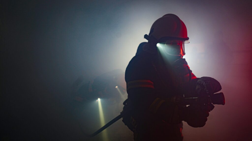 Fire fighter in smoke with a flashlight.